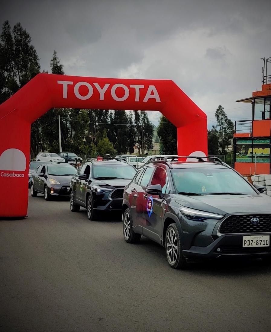 Caravana de vehículos Toyota saliendo bajo el arco de partida del evento